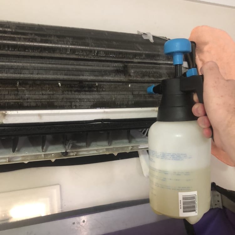 Air conditioner undergoing mould removal spray to help improve home health and reduce flu symptoms